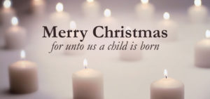 White candles with the text Merry Christmas - for unto us a child is born